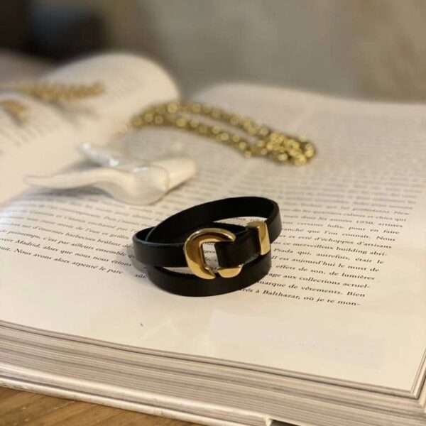 Ce splendide bracelet en cuir piqué s’accorde parfaitement avec son fermoir arqué en métal plaqué or.