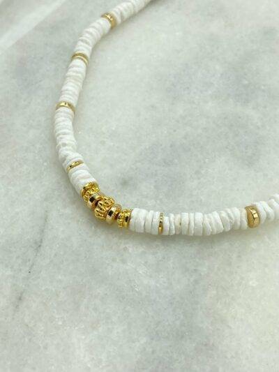 Un collier surfeur ajustable composé de perles naturelles de coquillage et de perles dorées à l'or fin. fermoir ajustable