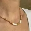 un collier de rhodocrosite associé à des perles dorées à l'or fin, des hématites et du coquillage, le collier de surfeur coloré en pierres naturelles