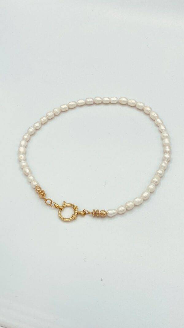 un grand classique que le collier de perles qui ici est surmonté d'un fermoir bouée pouvoir également être porté en pendentif