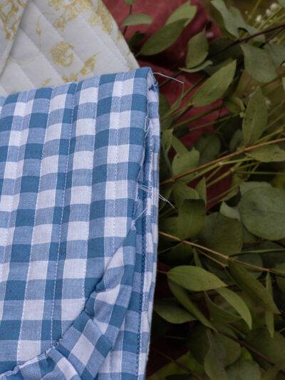 Détails du défaut de couture sur pochette à carreaux vichy bleus et blancs