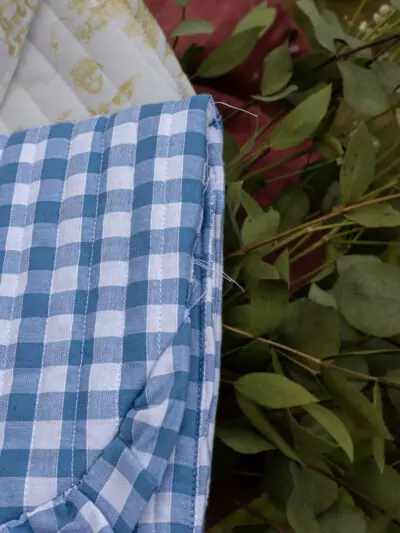 Détails du défaut de couture sur pochette à carreaux vichy bleus et blancs