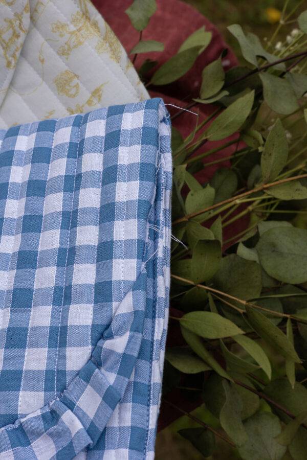 Détails du défaut de couture sur pochette à carreaux vichy bleus et blancs