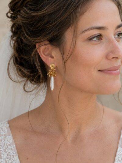 Boucles d'oreilles pendantes avec une perle d'eau douce allongée réhaussée d'acier inoxydable doré