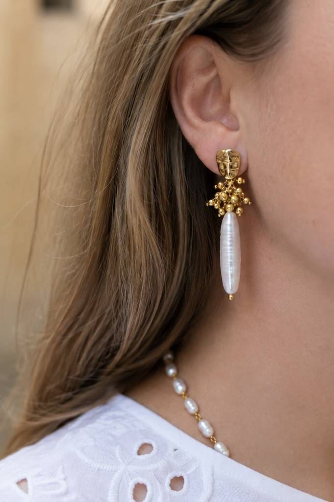 Boucles d'oreilles pendantes avec une perle d'eau douce allongée réhaussée d'acier inoxydable doré