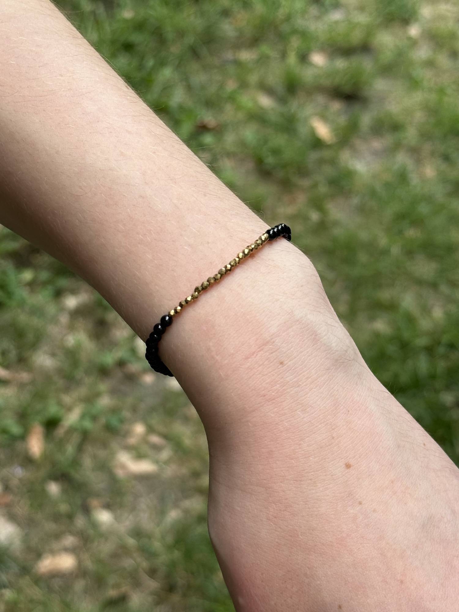 bracelet Ava en onyx noir et hématite dorée à l'or fin porté de face